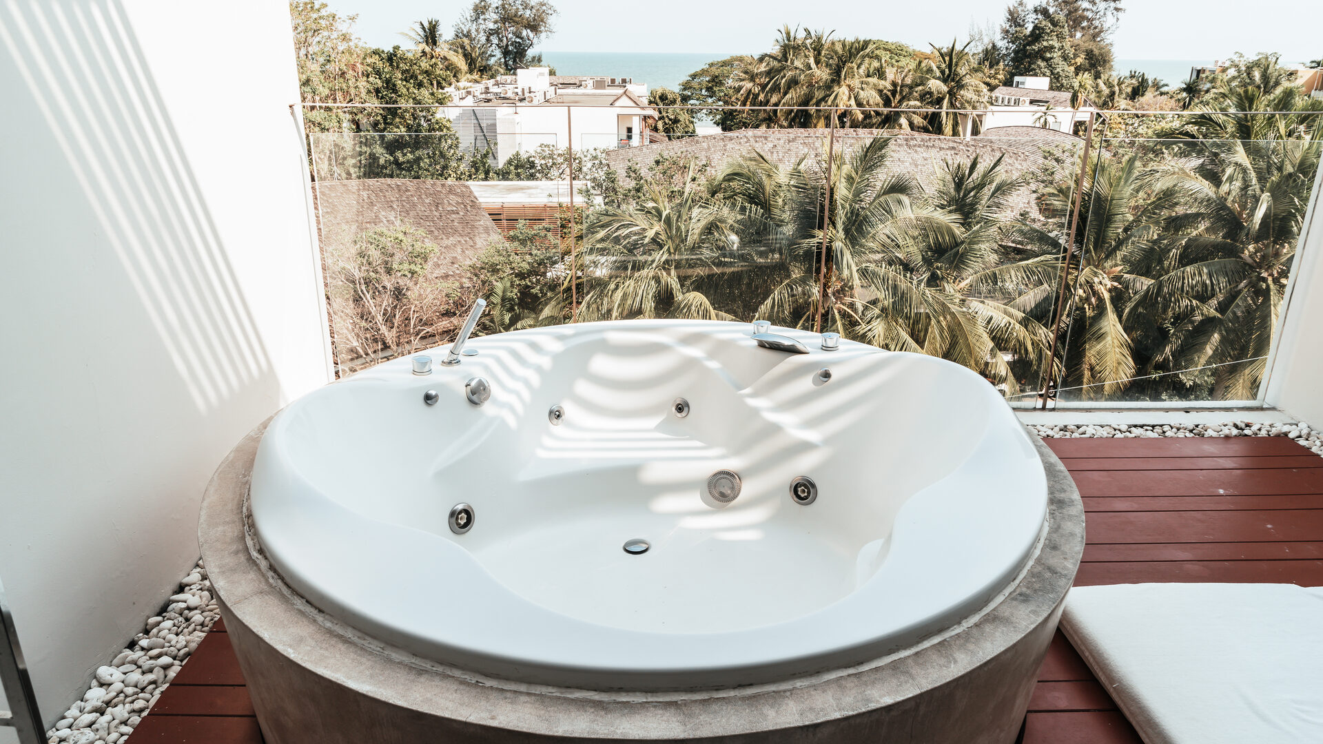 Private outdoor hot tub on a terrace overlooking palm trees and tropical scenery